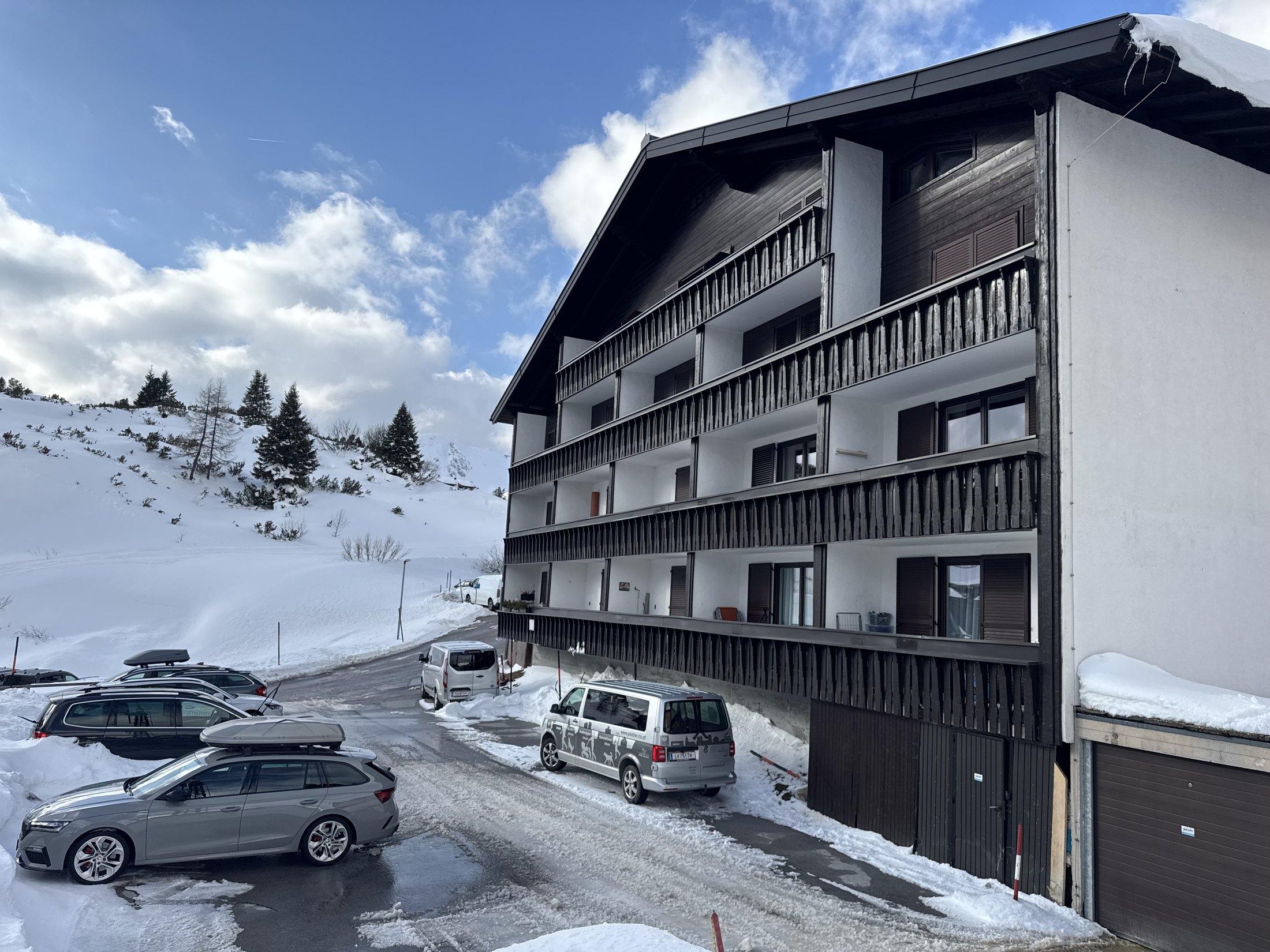 Hausansicht im Winter mit Parkplatz und Schnee